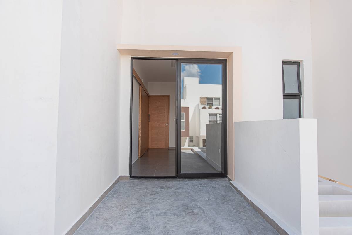 Acceso principal de Casa Arbolada — puertas corredizas y vestíbulo